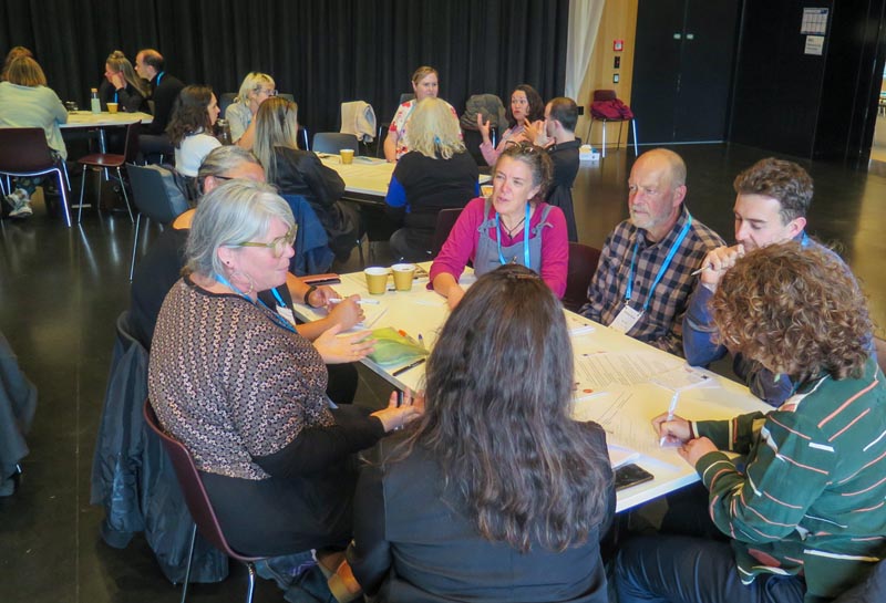 Participants sit around a table discussing a topic